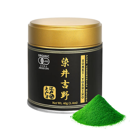 Somei-Yoshino Ceremonial Matcha powder in a black and gold resealable tin with a gold lid, shown with a small pile of the powder on a white background.