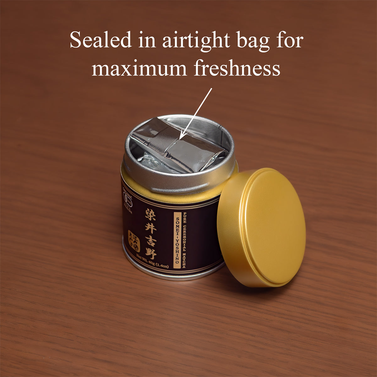 Open Somei-Yoshino Ceremonial Matcha tin on a wooden surface with the gold lid beside it, revealing the inner foil bag, text 'Sealed in airtight bag for maximum freshness'.