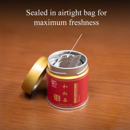 Open Wakocha Japanese black tea tin on a wooden surface with the gold lid beside it, revealing the inner foil bag, text 'Sealed in airtight bag for maximum freshness'.